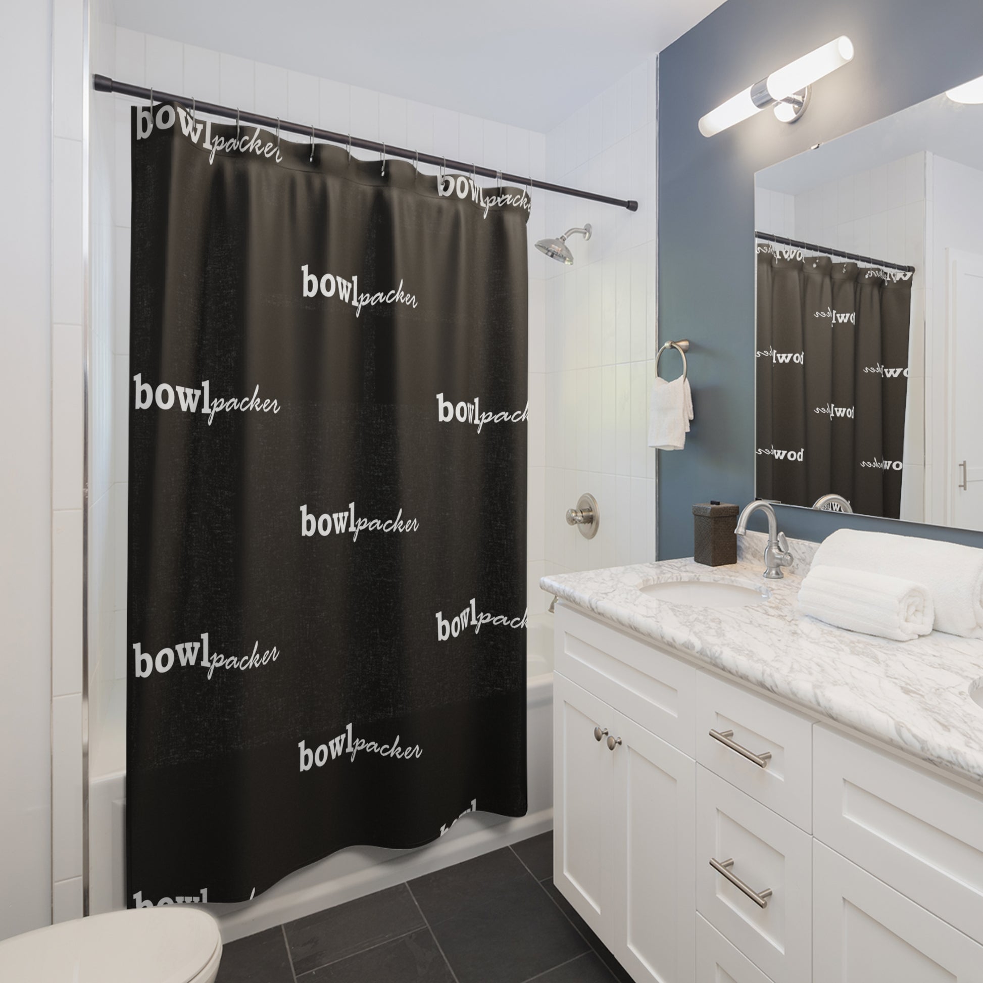 Black shower curtain which displays "bowl packer". This is shown in a bathroom.